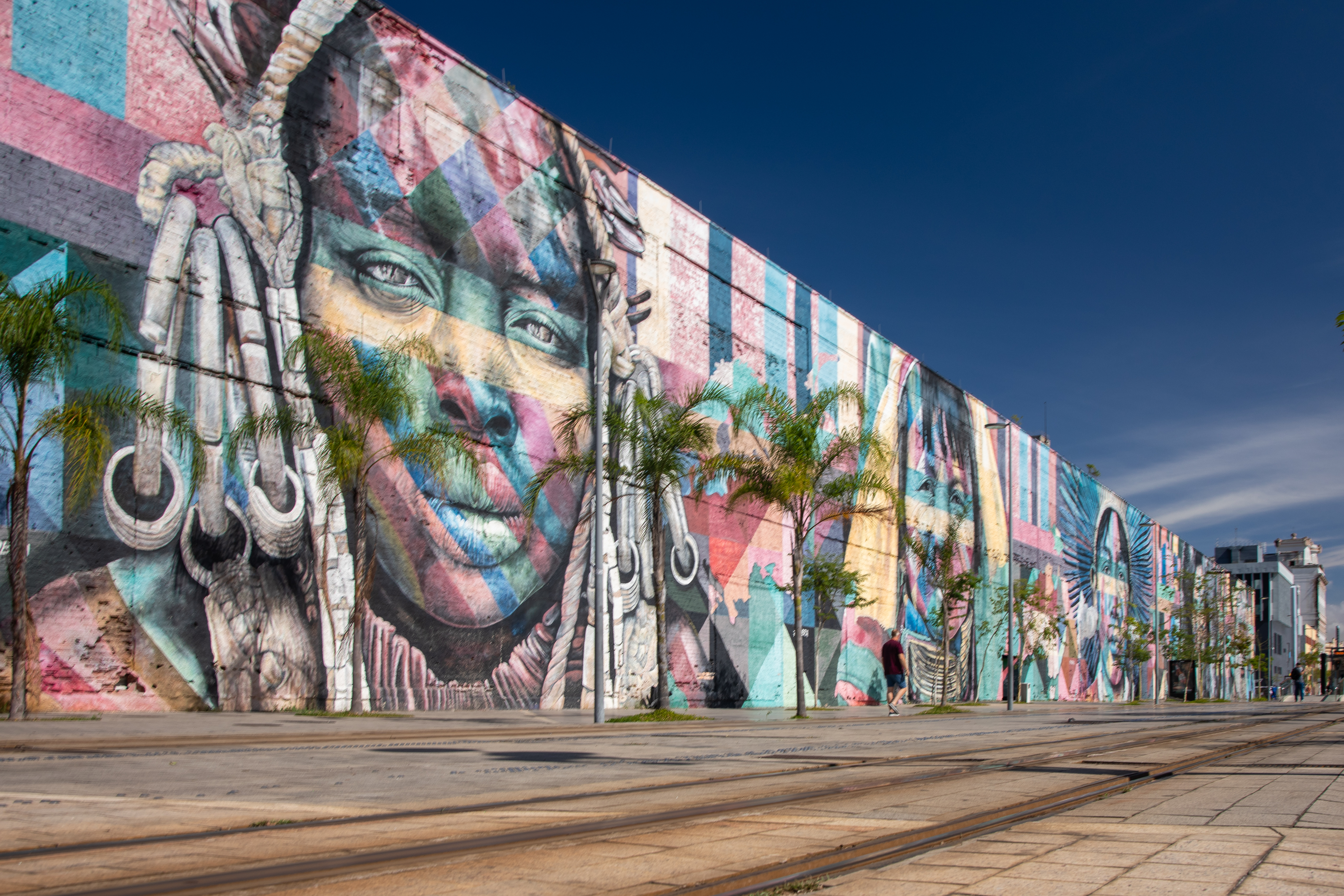 Mural monumental en la ciuda de Río. Representa rostros de personas, cargado de colores brillantes. 