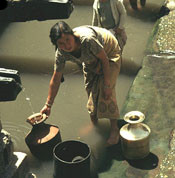 Mujer cargando tinajas de agua.